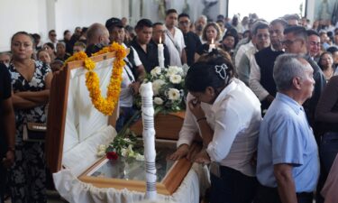 Mourners pay their respects at the casket of Alejandro Arcos