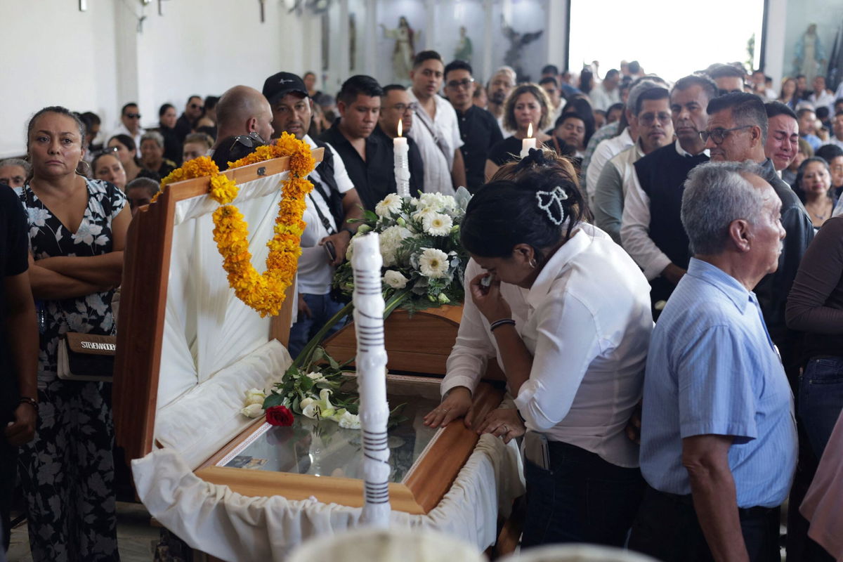 <i>Oscar Ramirez/Reuters via CNN Newsource</i><br/>Mourners pay their respects at the casket of Alejandro Arcos