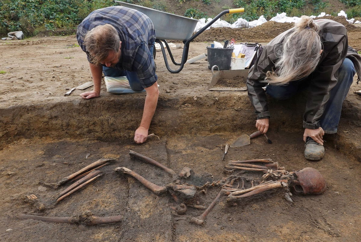 <i>Tom Little/Reuters via CNN Newsource</i><br/>Archaeologists excavate skeletons in a pit at the Viking-age burial site in the village of Asum