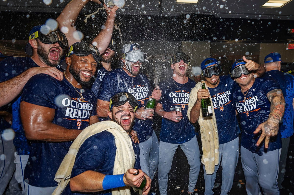 <i>Jason Allen/AP via CNN Newsource</i><br/>The New York Mets celebrate in the locker room after clinching a playoff berth with their come-from-behind victory against the Atlanta Braves.