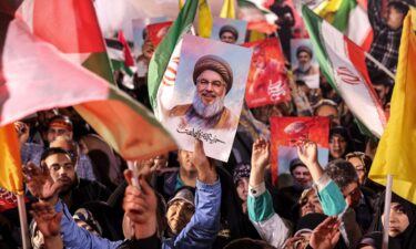 A demonstrator holds a sign showing the face of Hezbollah's slain leader Hassan Nasrallah