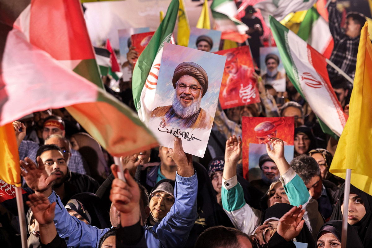 <i>Atta Kenare/AFP/Getty Images via CNN Newsource</i><br/>A demonstrator holds a sign showing the face of Hezbollah's slain leader Hassan Nasrallah