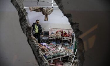 People inspect the damage caused by an artillery shell that hit the maternity hospital inside the Nasser Medical Complex