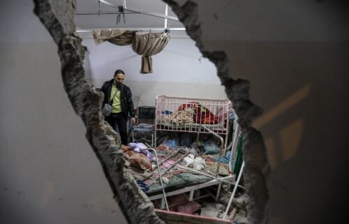 People inspect the damage caused by an artillery shell that hit the maternity hospital inside the Nasser Medical Complex