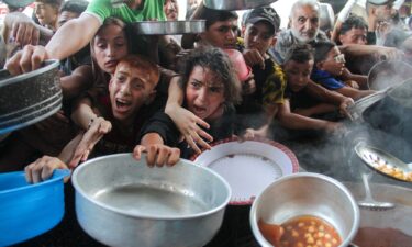 Palestinians receive food cooked by a charity kitchen in northern Gaza