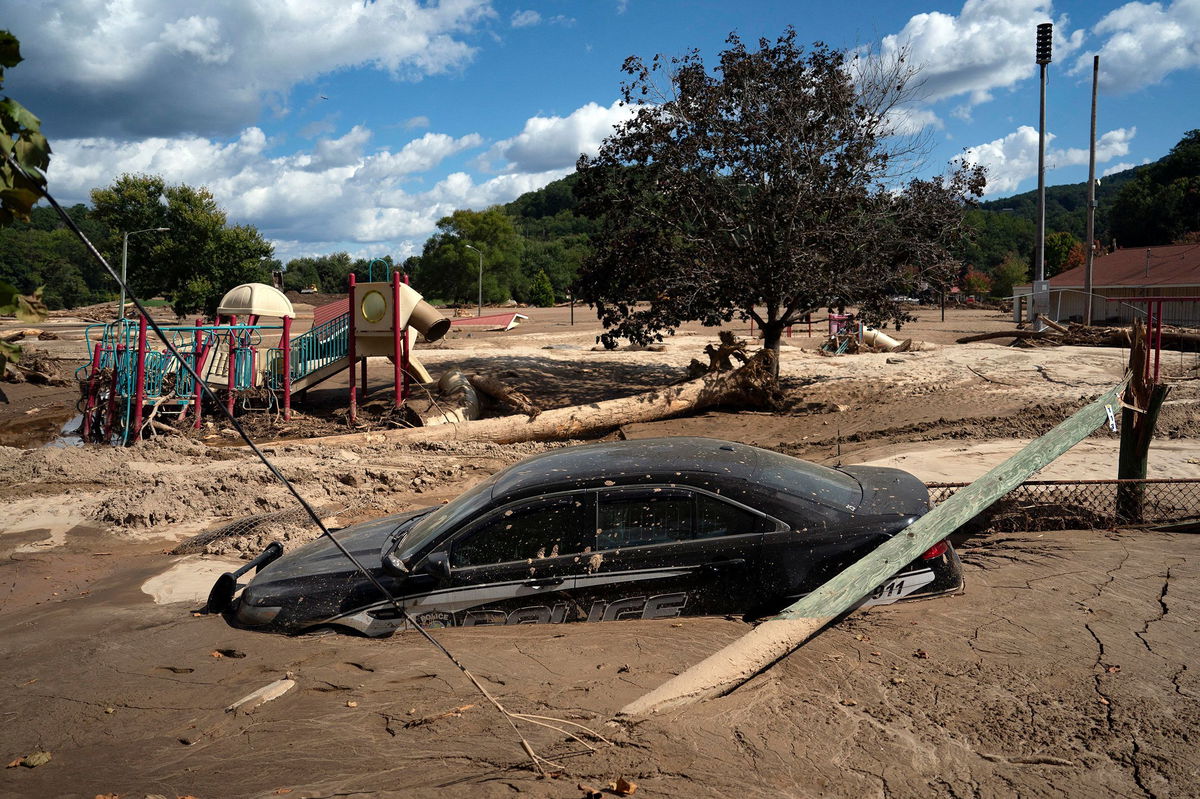 <i>Allison Joyce/AFP/Getty Images via CNN Newsource</i><br/>A local police car is seen half engulfed in mud