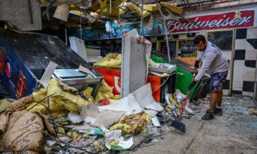 A man cleans debris inside a gas station store in Lakewood Park