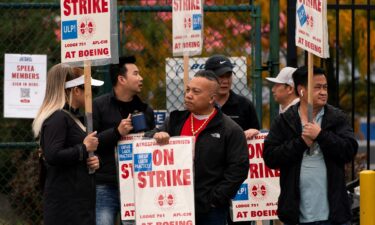 Boeing factory workers and supporters gather on a picket line near the entrance to a Boeing production facility in Renton