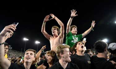 Oregon Ducks fans swarm the field after the game.