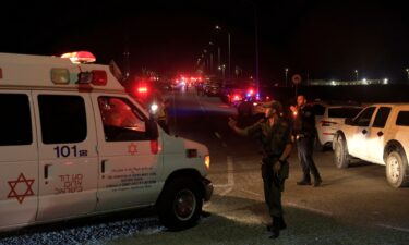 Emergency services personnel attend the scene of a drone strike on October 13 in Binyamina