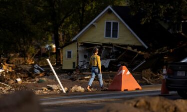 A woman walks by a zone affected by floods following the passing of Hurricane Helene