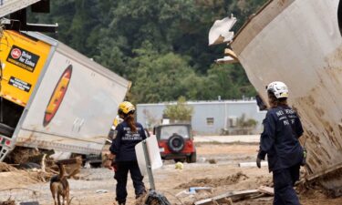 Members of the FEMA Urban Search and Rescue Task Force search a flood damaged area with a search canine in the aftermath of Hurricane Helene along the Swannanoa River on October 4