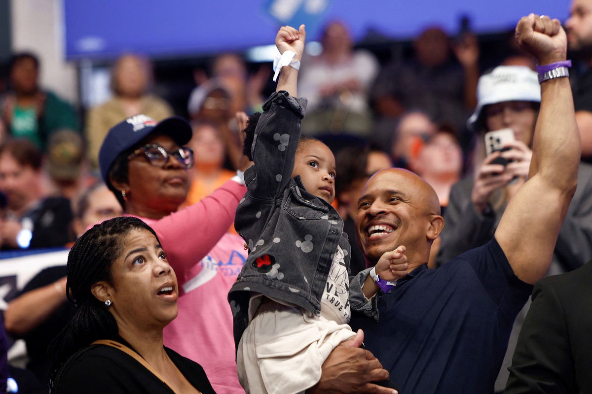 <i>Evelyn Hockstein/Reuters via CNN Newsource</i><br/>A child gestures during a campaign event for Vice President Kamala Harris at the Dort Financial Center in Flint