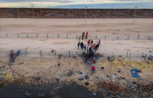 Migrants pass through razor wire after crossing the Rio Grande into El Paso