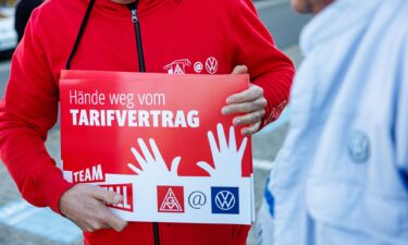 A Volkswagen employee holds a placard reading "Hands off the collective agreement" during a VW works council event in Zwickau