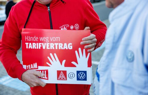 A Volkswagen employee holds a placard reading "Hands off the collective agreement" during a VW works council event in Zwickau