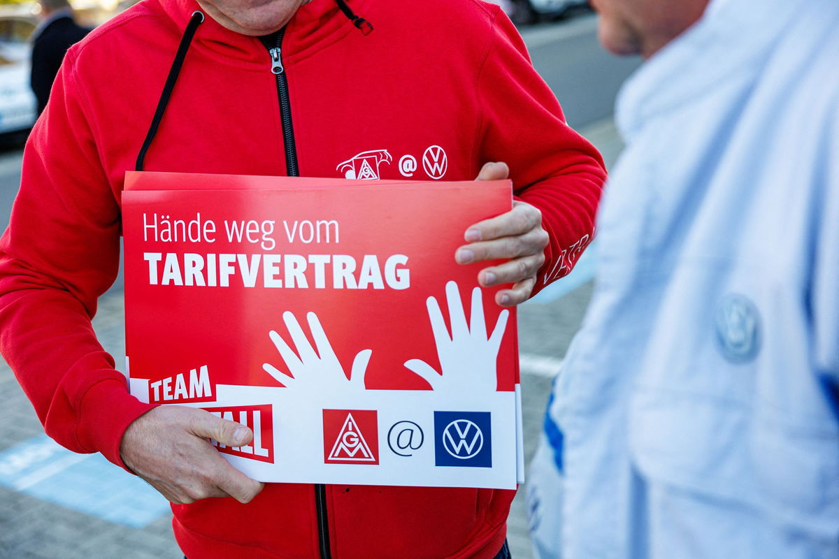 <i>Jens Schlueter/AFP/Getty Images via CNN Newsource</i><br/>A Volkswagen employee holds a placard reading 