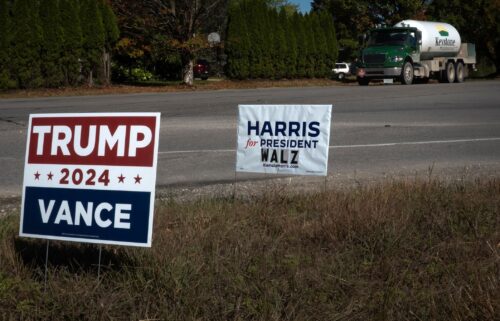 Signs showing support for both Kamala Harris and Donald Trump sit along a rural highway near Traverse City