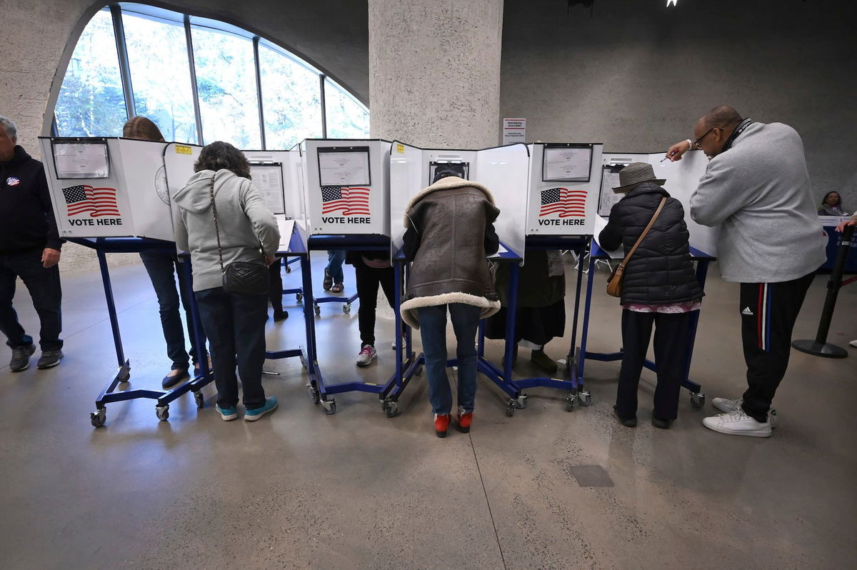 <i>Anthony Behar/Sipa USA/AP via CNN Newsource</i><br/>Voters fill in ballots at a voting site set up inside the American Museum of Natural History during the third day of early voting in New York on October 26.