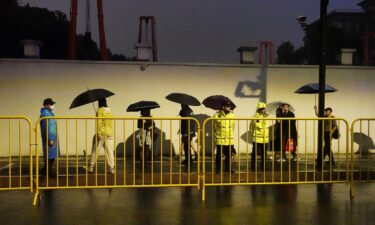 Police officers keep watch near barricades set up along Julu Road where people in Halloween costumes gathered the year before