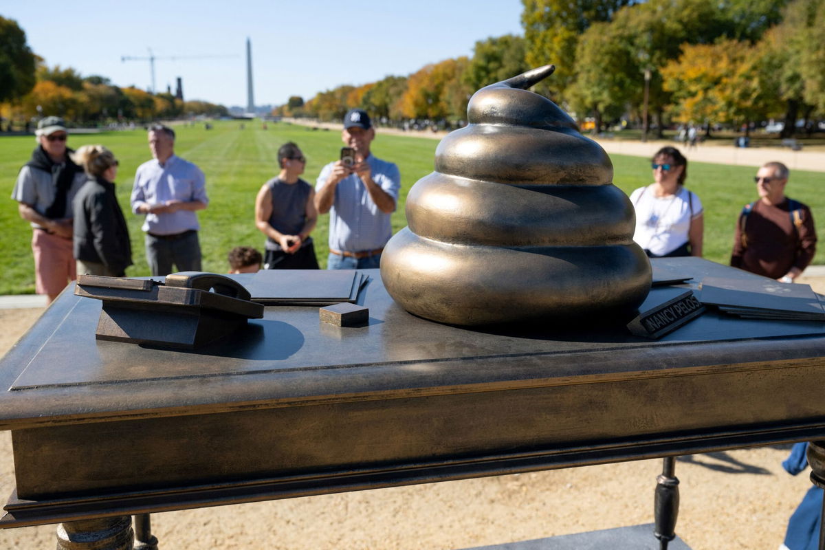 <i>Saul Loeb/AFP/Getty Images via CNN Newsource</i><br/>People look at a bronze art installation depicting a pile of feces on former US Speaker of the House Nancy Pelosi's desk on the National Mall near the US Capitol in Washington