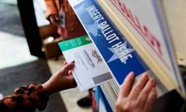 A person drops off a mail-in ballot on October 15