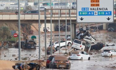 Damaged cars are seen along a road affected by torrential rains that caused flooding