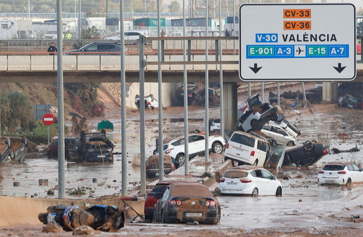 <i>Eva Manez/Reuters via CNN Newsource</i><br/>Damaged cars are seen along a road affected by torrential rains that caused flooding