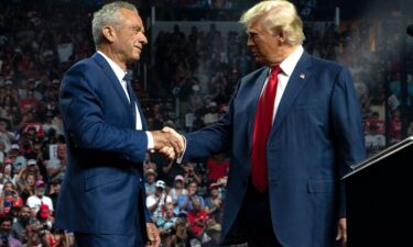 Robert F. Kennedy Jr. and former President Donald Trump shake hands during a campaign rally at Desert Diamond Arena on August 23