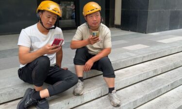 Food delivery worker Yang (left) speaks to CNN about his plight.