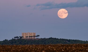 The full hunter's moon rises behind Castel del Monte in Andria