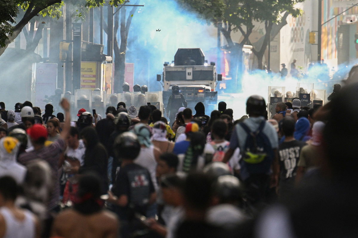 <i>Federico Parra/AFP/Getty Images/File via CNN Newsource</i><br/>Demonstrators clash with police close to an armoured police car during a protest against Venezuelan President Nicolas Maduro in Caracas