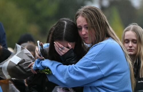 Fans comforting each other while paying tribute to Liam Payne at a memorial held on Sunday in London's Hyde Park.