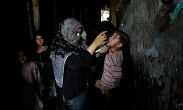 A health worker administers a polio vaccine to a child in a downtown area of Lahore