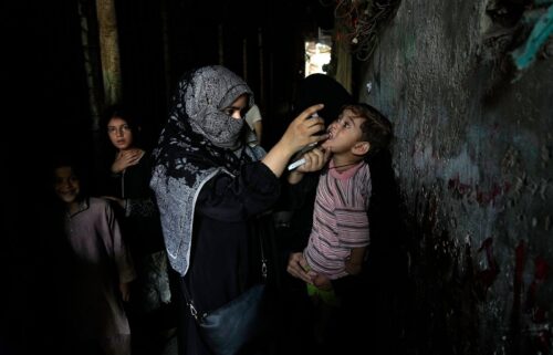 A health worker administers a polio vaccine to a child in a downtown area of Lahore