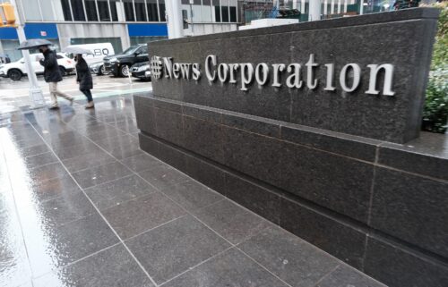 People walk past 1211 Avenue of the Americas the headquarters for News Corp on February 4