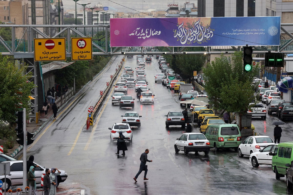 <i>Atta Kenare/AFP/Getty Images via CNN Newsource</i><br/>A man crosses the street amid traffic on a rainy day on a main road in northern Tehran on September 28.