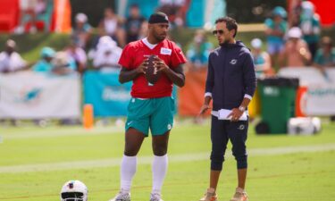 Miami Dolphins quarterback Tua Tagovailoa and head coach Mike McDaniel talk during training camp.