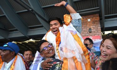 Nepali mountaineer Nima Rinji Sherpa waves upon his arrival at the airport in Kathmandu on October 14.