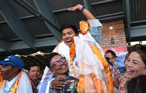 Nepali mountaineer Nima Rinji Sherpa waves upon his arrival at the airport in Kathmandu on October 14.