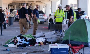 Louisiana State police give instructions to people living in a homeless encampment to move to a different pre-designated location as they perform a sweep in advance of a Taylor Swift concert in New Orleans