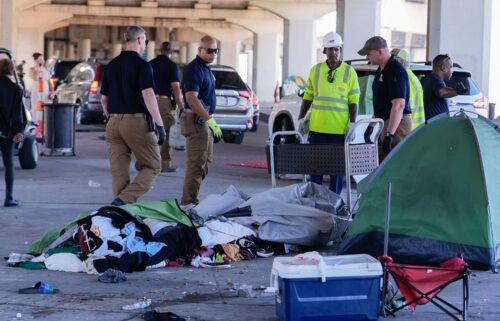 Louisiana State police give instructions to people living in a homeless encampment to move to a different pre-designated location as they perform a sweep in advance of a Taylor Swift concert in New Orleans