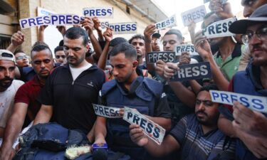 Mourners and colleagues hold 'press' signs around the body of Al-Jazeera Arabic journalist Ismail al-Ghoul