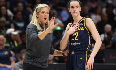 Indiana Fever guard Caitlin Clark talking to head coach Christie Sides during a preseason game.