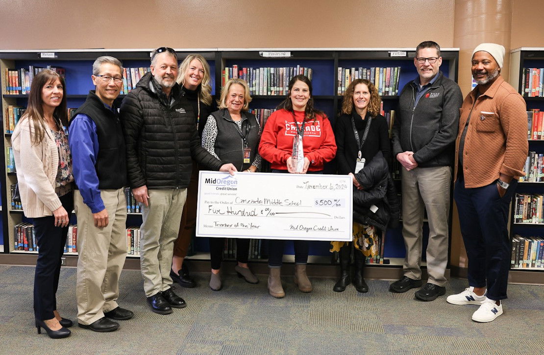 Superintendent Steven Cook congratulates Educator of the Year Lauren Miller Wednesday at Cascade Middle School. From right, Board Chair Marcus LeGrand, Superintendent Steven Cook, Board Director Cameron Fischer, Learning Specialist Lauren Miller, Board Director Shirley Olson, Deputy Superintendent Lisa Birk, and from Mid Oregon Credit Union, Kyle Frick, David Lau and Tina Amato.