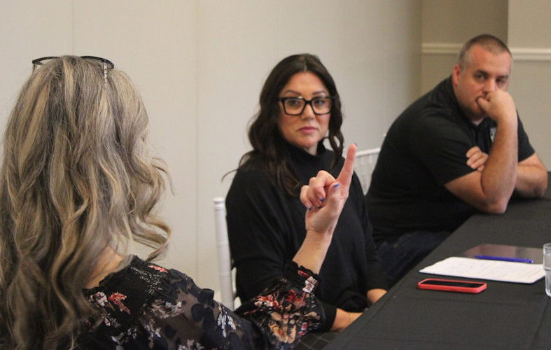 U.S. Rep. Lori Chavez-DeRemer, R-Oregon, listens to Portland business owner Ann Naughton while Portland Police Sgt. Aaron Schmautz looks on.