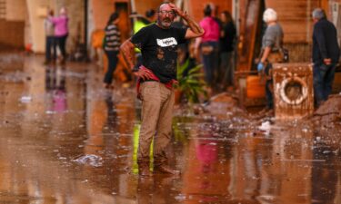 A man reacts in front of houses affected by floods in Utiel