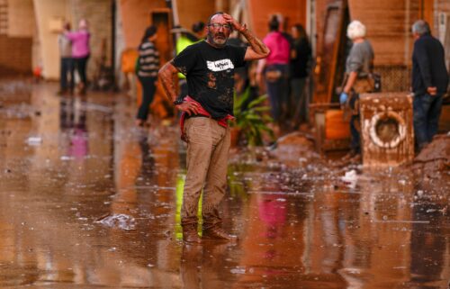 A man reacts in front of houses affected by floods in Utiel