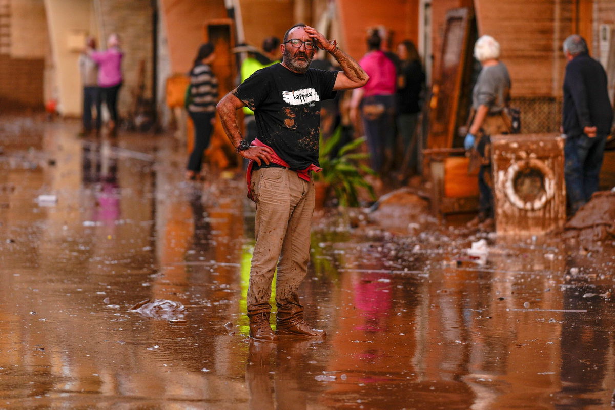 <i>Manu Fernandez/AP via CNN Newsource</i><br/>A man reacts in front of houses affected by floods in Utiel