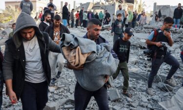 A man carries the body of a Palestinian killed by an Israeli airstrike on a house